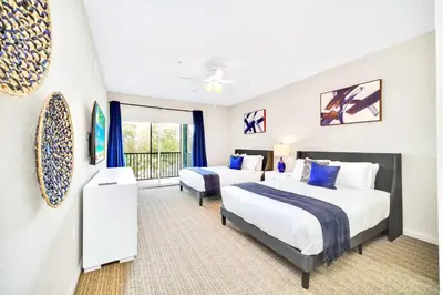 a hotel room with two beds and a balcony at 2BR Queen bed Condo - Pool - Near Disney in Orlando