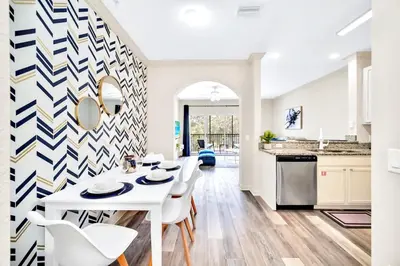 a kitchen with a white table and white chairs at 2BR Queen bed Condo - Pool - Near Disney in Orlando