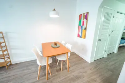 a dining room with a wooden table and white chairs at Apt Orlando 11th Floor 5 min from Disney in Orlando