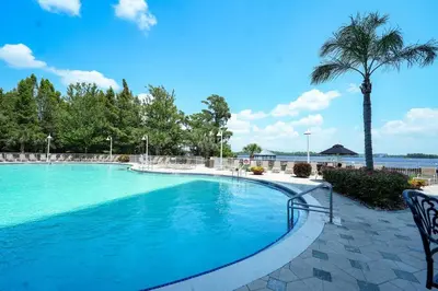 a swimming pool at a resort with a palm tree at Apt Orlando 11th floor 5 minutes from Disney in Orlando