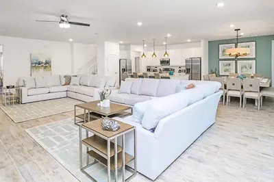a living room with a white couch and a table at 15BR Mansion Near Disney Private Pool Hot Tub in Kissimmee