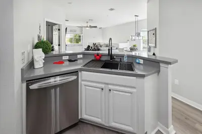 a kitchen with white cabinets and a sink at Amazing Disney Themed Oasis 3BR near Parks townhouse in Orlando