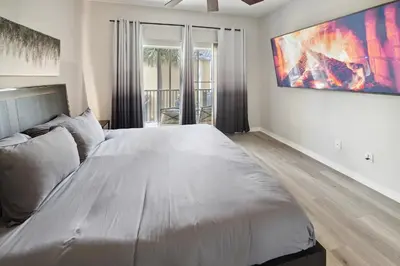a large bed in a bedroom with a large painting on the wall at Amazing Disney Themed Oasis 3BR near Parks townhouse in Orlando
