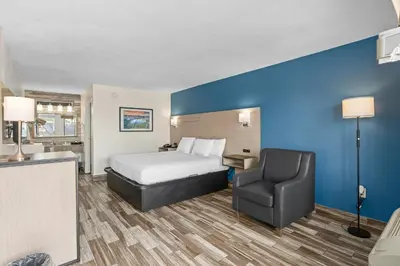 a hotel room with a bed and a chair at Baymont by Wyndham Orlando Downtown in Orlando