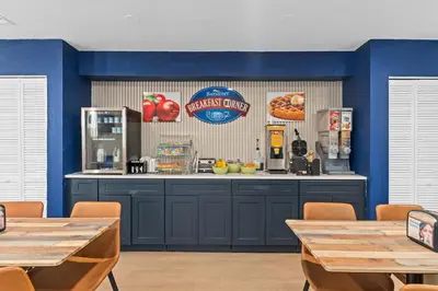 a kitchen with blue walls and a counter with tables at Baymont by Wyndham Orlando Downtown in Orlando