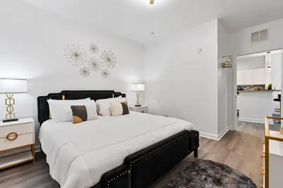 a bedroom with a large bed and a kitchen at Amazing Apartment 3Brdm - 5 miles from Disney in Kissimmee