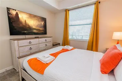 a bedroom with a bed with a dresser and a window at The Epic Miami Supreme Storey Lake in Kissimmee