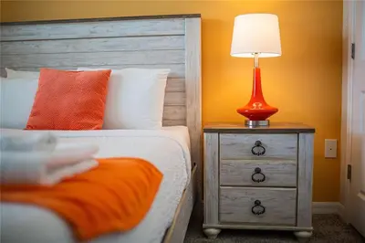 a bedroom with a bed and a lamp on a night stand at The Epic Miami Supreme Storey Lake in Kissimmee