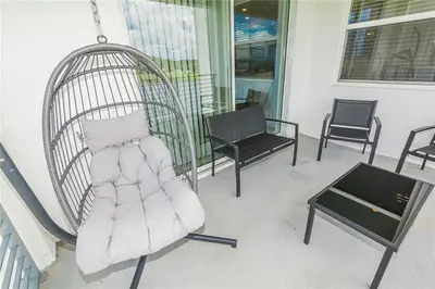 a porch with a swing and chairs and a table at The Epic Miami Supreme Storey Lake in Kissimmee