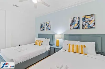 two beds in a bedroom with blue and white at The Epic Madrid Vista Cay Orlando in Orlando