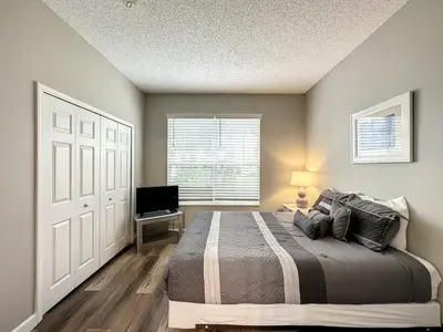 a bedroom with a bed and a television in it at 4 BED 3 BATH IN A GATED COMMUNITY WITH POOL villa in Kissimmee