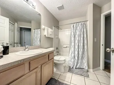 a bathroom with a sink and a toilet and a shower at 4 BED 3 BATH IN A GATED COMMUNITY WITH POOL villa in Kissimmee