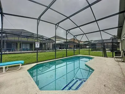a large swimming pool with a covering over it at 4 BED 3 BATH IN A GATED COMMUNITY WITH POOL villa in Kissimmee