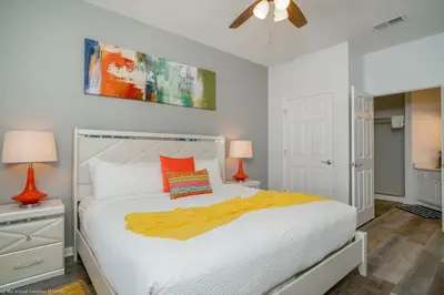 a bedroom with a white bed with a yellow blanket on it at Luxury Remodeled! WOW! in Orlando