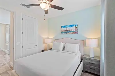 a bedroom with a white bed and a ceiling fan at 2959 Castaway Lane in Orlando