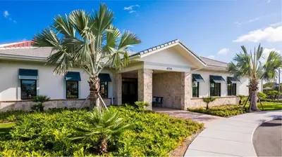 a house with palm trees in front of it at Magical 9BR Villa by Disney w Pool Theme Room in Kissimmee