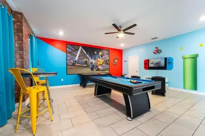 a room with a ping pong table and a tv at Magical 9BR Villa by Disney w Pool Theme Room in Kissimmee