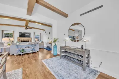 a living room with a table and a mirror at Best of Both Worlds Lakehouse in Orlando