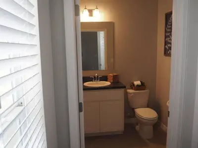 a bathroom with a sink and a toilet and a mirror at Luxurious Farm Style House in Kissimmee