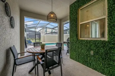 a dining room with a table and a green wall at Ultimate Luxury Home-Private Pool Themed Bedroom in Kissimmee