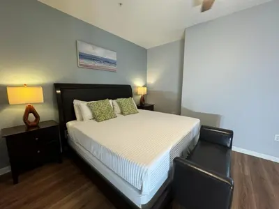 a bedroom with a bed with two chairs and a lamp at Vista Cay Hideway Luxury Home By Universal Orlando in Orlando
