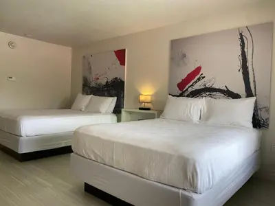 a bedroom with two beds and a painting on the wall at A & S Vacation Rooms in Kissimmee