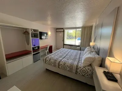 a hotel room with a bed and a desk at A & S Vacation Rooms in Kissimmee