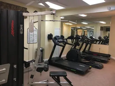 a gym with several tread machines in a room at Charming 3BR home in Kissimmee with private pool and lake view, perfect for families. in Kissimmee