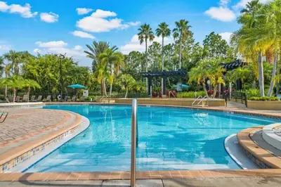 a swimming pool at a resort with palm trees at Vista Cay Getaway Luxury By Universal Orlando in Orlando