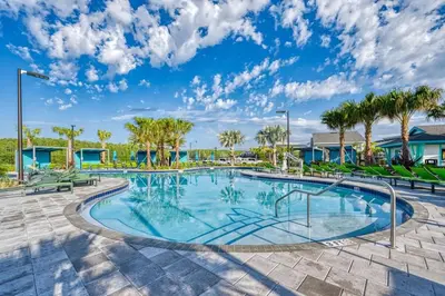 a swimming pool with trees and palm trees at Opulent Retreat Themed Bedrooms and Pool Paradise in Kissimmee