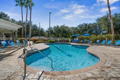 a swimming pool with blue lounge chairs and a resort at HSO - Family Apartments Close to Disney World & Universal in Orlando