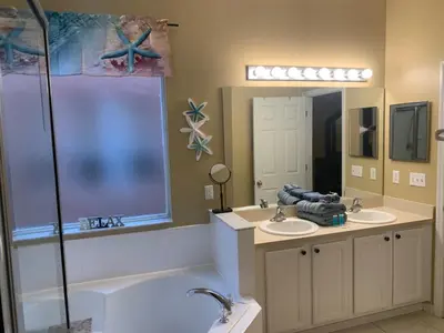 a bathroom with two sinks and a tub and a shower at Complete Vacation in exclusive 7 Bed resort home, in Kissimmee