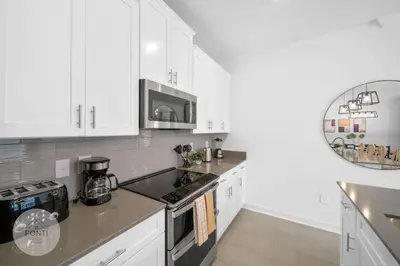 a kitchen with white cabinets and a stove top oven at BRAND NEW 4BR House Waterpark Disney Orlando 2697 in Kissimmee