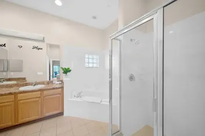 a white bathroom with a shower and a sink at Caribe Cove Resort 3BR Condo Apt Disney Orlando in Kissimmee