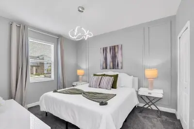 a white bedroom with a large bed and a window at Luxury Incredible Themed Home best vacation in Kissimmee