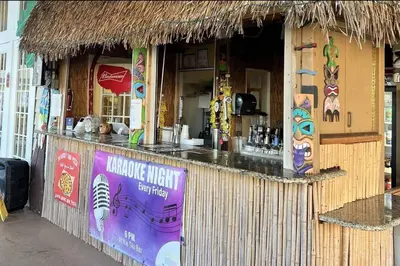 a restaurant with a bar with a thatch roof at Awesome 3 beds Villa at Seven Dwarfs in Kissimmee