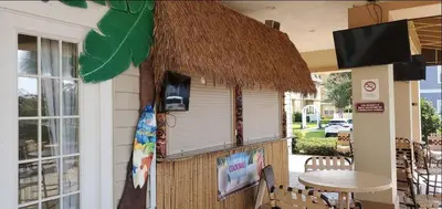 a restaurant with a straw roof and a table at Awesome 3 beds Villa at Seven Dwarfs in Kissimmee