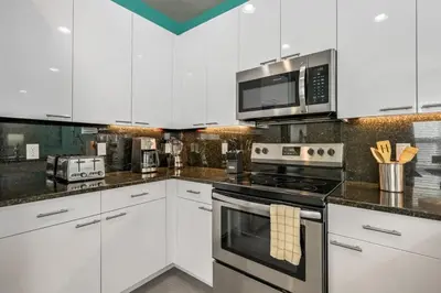 a kitchen with white cabinets and a stove and microwave at Charming Villa with Private Pool Bliss in Orlando