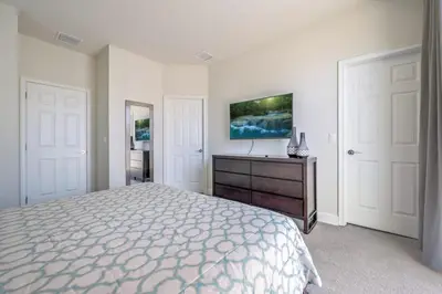 a bedroom with a bed and a dresser and a tv at Charming Villa with Private Pool Bliss in Orlando