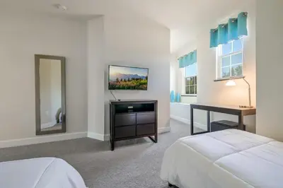 a bedroom with a bed and a desk and a mirror at Charming Villa with Private Pool Bliss in Orlando