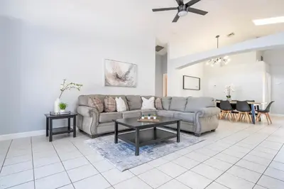 a living room with a couch and a table at Magical 5-Bedroom Retreat w/ Pool, 3 Ensuite Bedrooms, Near Disney, and Internet! in Kissimmee