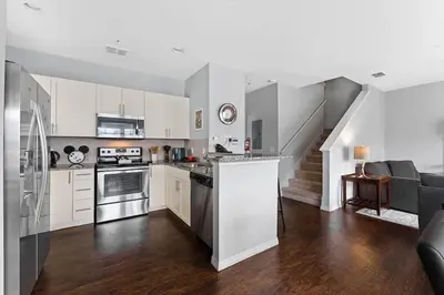 a large kitchen with white cabinets and a staircase at Freshly Redesigned 4BR at West Lucaya WL3211 in Kissimmee