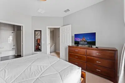 a bedroom with a bed and a dresser with a flat screen tv at Freshly Redesigned 4BR at West Lucaya WL3211 in Kissimmee