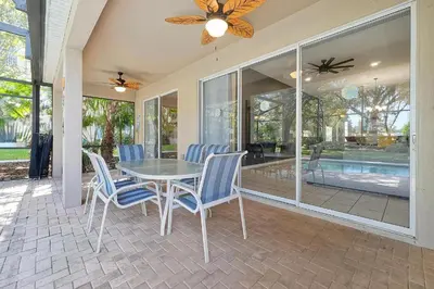 a dining room with a table and chairs on a patio at Windsor Hills 4BR's Mickeys Ranch Near Disney in Orlando