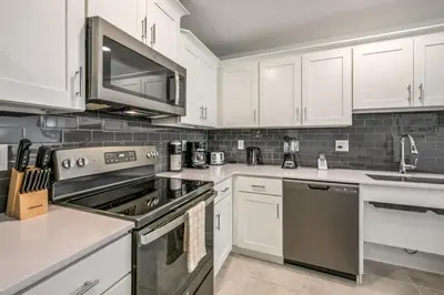 a kitchen with white cabinets and stainless steel appliances at Spacious Beautiful 3-BR Condo Prime Location in Kissimmee