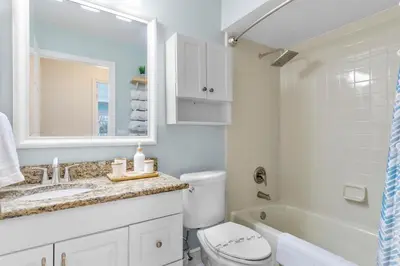 a bathroom with a toilet and a sink and a tub at Beautiful Tropical Home with Private Heated and Chilled Pool in Kissimmee