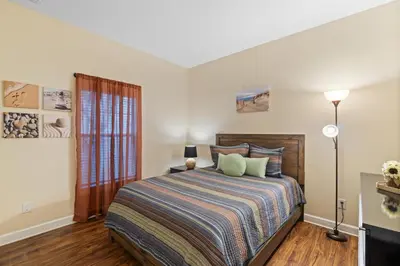a bedroom with a bed with a striped blanket at 3071 Beach Palm in Kissimmee
