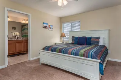 a bedroom with a white bed and a bathroom at 3071 Beach Palm in Kissimmee
