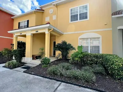 a large yellow house with plants in front of it at Beautiful 4 beds at Paradise Palms Resort in Kissimmee