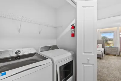 a white kitchen with a stove and a washer at House with pool in resort in Kissimmee